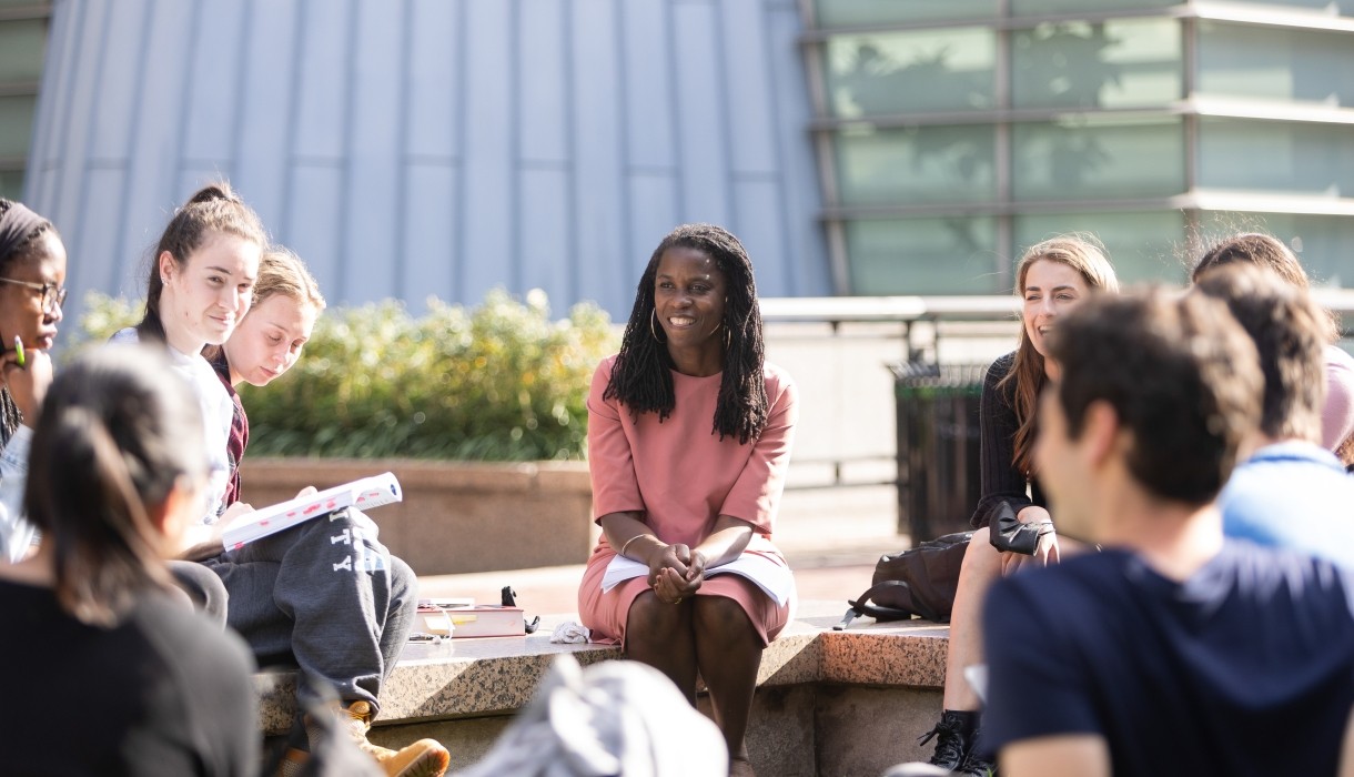 Olatunde Johnson sitting with students